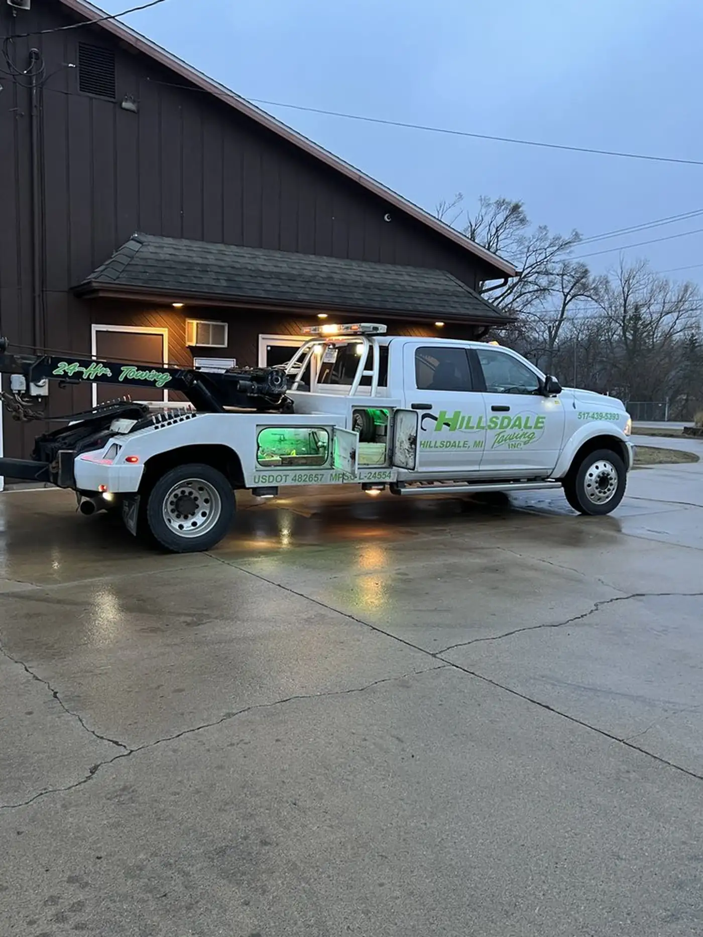 Hillsdale Towing tow truck on a rural Hillsdale County road at dusk